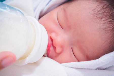 Mother feeding newborn baby from the bottleの写真素材