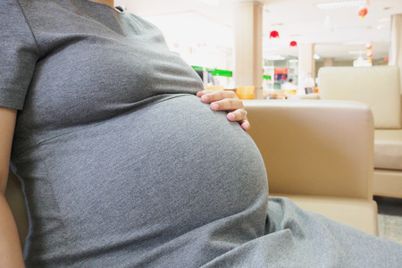 Asian pregnant woman touching her bellyの写真素材