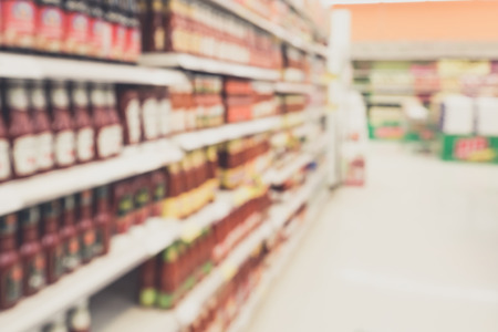 ketchup sauce seasoning bottles products in supermarket shelves blurred backgroundの写真素材
