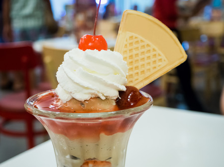 ice cream sundae with cherry and whipped creamの写真素材