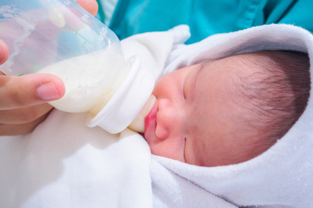 Mother feeding newborn baby from the bottleの写真素材