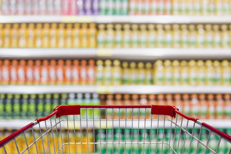 Shopping cart view in Supermarket with beverage product Shelves in blurry for backgroundの写真素材