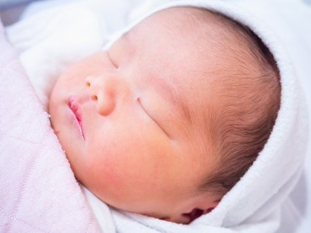 Cute newborn asian baby girl sleepingの写真素材