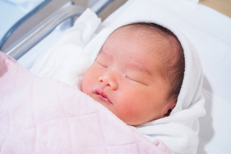 Cute newborn asian baby girl sleepingの写真素材