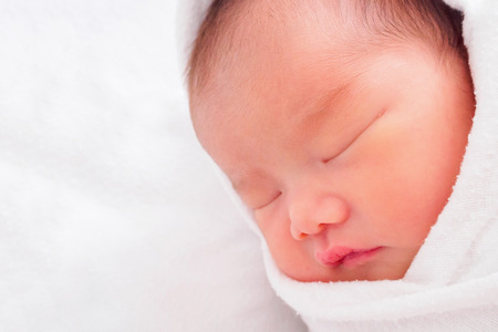 Cute newborn asian baby girl sleepingの写真素材