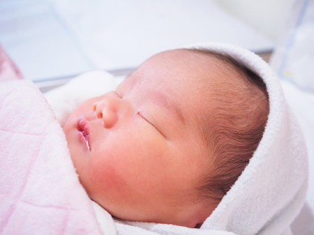 Cute newborn asian baby girl sleepingの写真素材