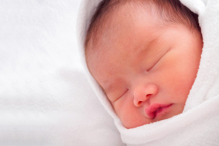 Cute newborn asian baby girl sleepingの写真素材