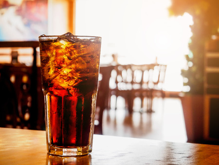 Cola glass soft drink with ice on wood table in restaurant backgroundの写真素材