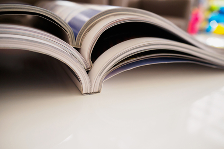pile of magazines stack on white table in living room, close upの写真素材