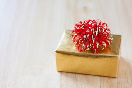golden gift box on wood table for christmas backgroundの写真素材
