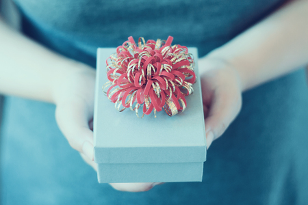 Woman holding and giving gift box, vintage toneの写真素材