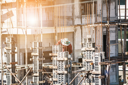 Worker pouring concrete to formwork frames at construction site to building houseの写真素材