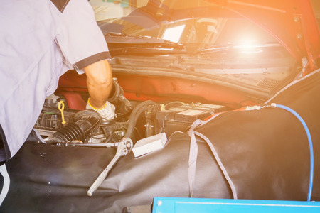 Mechanic with wrench working and repair car engine in car service centreの写真素材