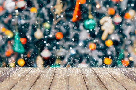 Christmas tree decorated abstract blur snow background with wood tableの写真素材