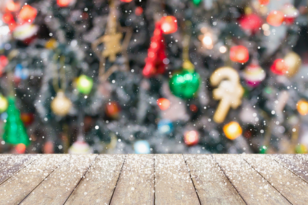 Christmas tree decorated abstract blur snow background with wood tableの写真素材