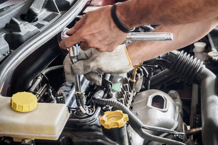 Mechanic with wrench working and repair car engine in car service centreの写真素材