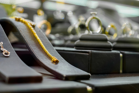 Gold jewelry diamond shop with bracelet rings and necklaces in luxury retail store window display showcaseの写真素材