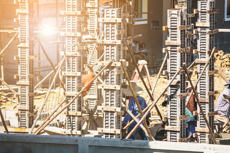 Worker pouring concrete to formwork frames at construction site to building house