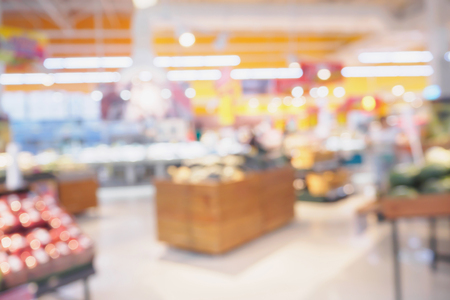 Supermarket with fresh fruits and vegetable on shelves in store blurred grocery backgroundの写真素材