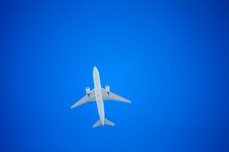 Airplane flying with blue skyの写真素材