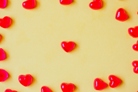 Valentines day background with red heart shape candy on yellow backgroundの写真素材