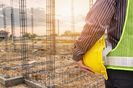 Asian business man construction engineer worker in protective helmet and blueprints paper on hand at...