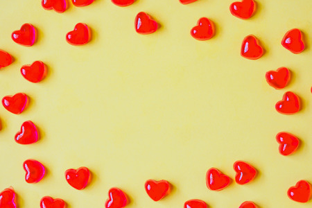 Valentines day background with red heart shape candy on yellow backgroundの写真素材
