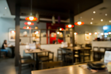 Abstract cafe coffee shoop restaurant interior blur background with bokeh lightの写真素材