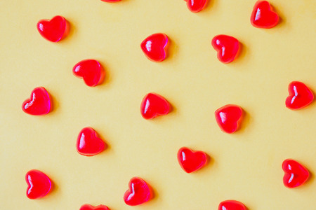 Valentines day background with red heart shape candy on yellow backgroundの写真素材