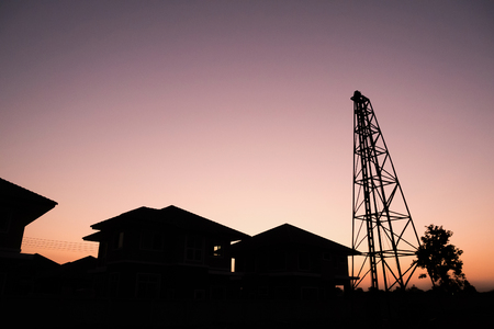 Silhouette pile driver at house building construction site with sunset skyの写真素材