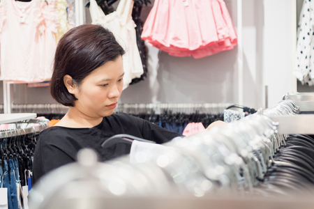 Beautiful asian woman shopping in fashion clothes storeの写真素材