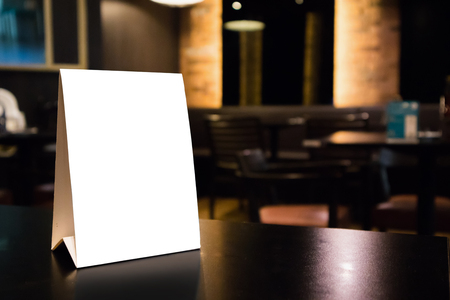 Mockup empty white label menu frame on table with cafe restaurant interior backgroundの写真素材