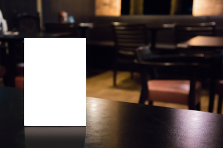 Mockup empty white label menu frame on table with cafe restaurant interior backgroundの写真素材