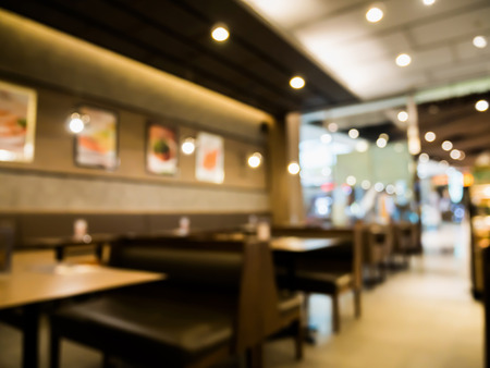 Abstract cafe coffee shoop restaurant interior blur background with bokeh lightの写真素材