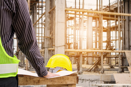young business man professional engineer worker at the house building construction site with blueprintの写真素材