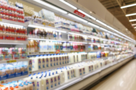 Abstract blur supermarket grocery store refrigerator shelves with fresh milk bottles and dairy productsの写真素材