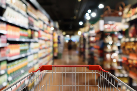 Shopping cart with supermarket aisle blur abstract backgroundの写真素材