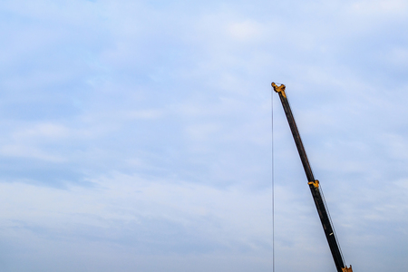 yellow telescopic arms of mobile construction crane truck at house construction siteの写真素材