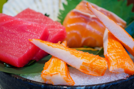 Sashimi set on ice with salmon tuna with chopsticksの写真素材