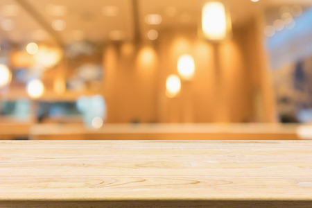 wood table with abstract blurred cafe restaurant with bokeh lights defocused backgroundの写真素材