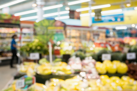 Supermarket grocery store with fruit and vegetable on shelves blurred backgroundの写真素材