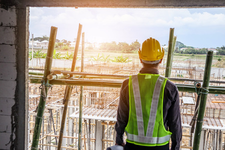 Asian business man construction engineer worker in protective helmet and blueprints paper on hand at...
