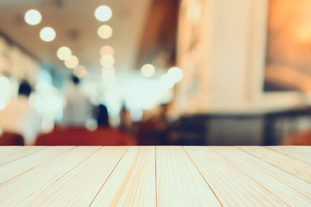 Wood table with Restaurant cafe or coffee shop interior with people abstract defocused blur backgroundの写真素材