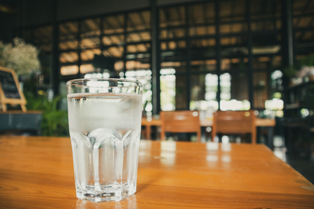 glass of mineral water on wood table in restaurantの写真素材
