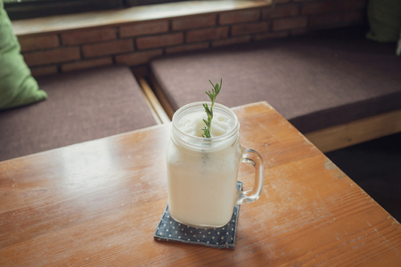 fresh coconut water frappe with rosemary leaf on restaurant tableの写真素材