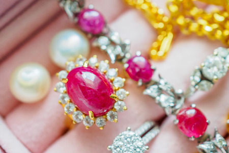 Gold and silver diamond gemstone ruby ring necklaces and pearl earrings in luxury jewelry boxの写真素材