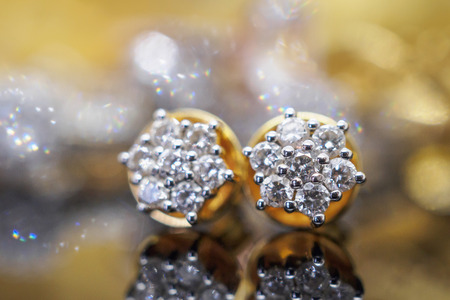 Luxury gold Jewelry diamond earrings with reflection on black backgroundの写真素材
