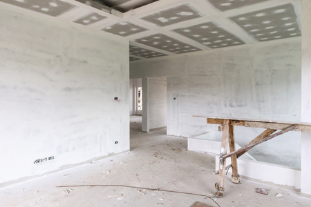 Empty room interior with gypsum board ceiling at house construction siteの写真素材