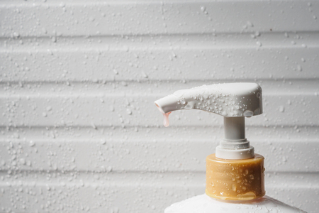 Water drop on liquid soap dispenser pump during bath timeの写真素材
