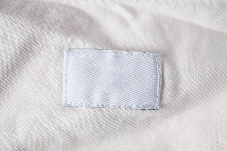 White blank laundry care clothes label on cotton shirt